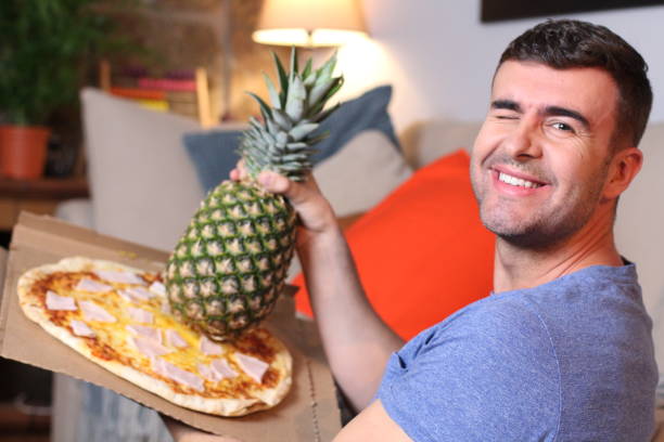istock Man loving the mix between pizza and pineapple 1209862402