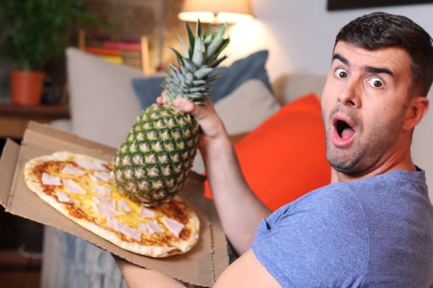 funny man holding pineapple and pizza - grotesque imagens e fotografias de stock