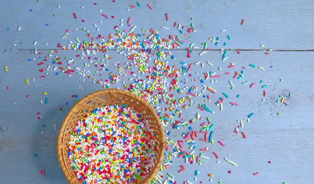 Colourful sugar sprinkles for cakes and bakery on a blue wooden surface. Stock Image.