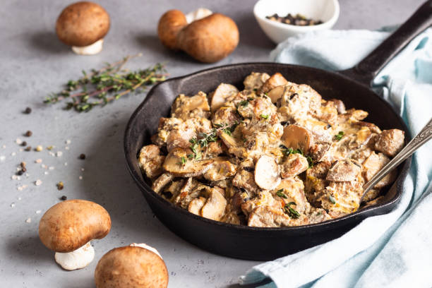 istock Meat stewed with mushroom and thyme in a cast-iron pan.  Grey concrete background. Copy space. 1209865710