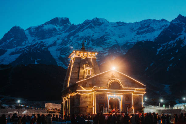 vista delle luci del tempio di kedarnath di notte con montagne sullo sfondo a uttarakhand, india - shiva india hinduism temple foto e immagini stock