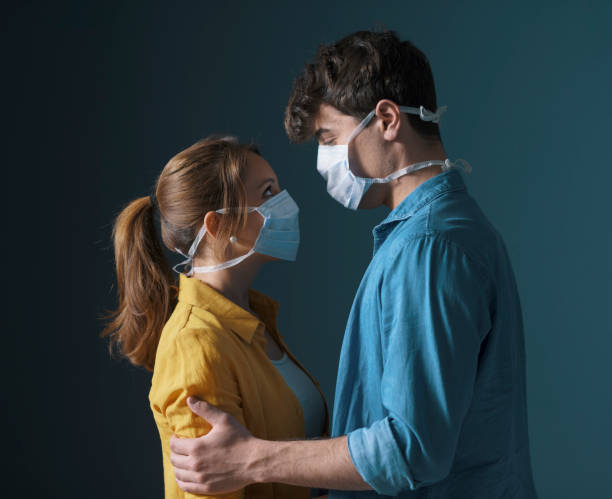 young loving couple wearing face masks - couple indoors studio shot horizontal imagens e fotografias de stock