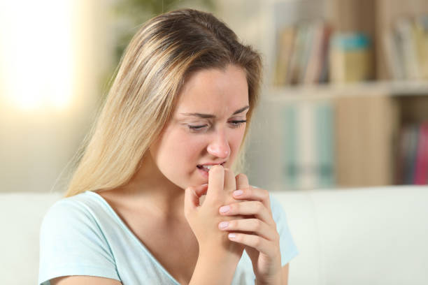 Stressed blonde teenage girl biting her nails Stressed blonde teenage girl biting her nails nail biting stock pictures, royalty-free photos & images