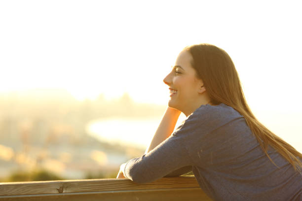 istock Happy woman looking away on a sunny terrace 1209867110