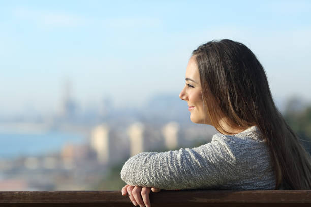 istock Confident woman looking away with city background 1209867662