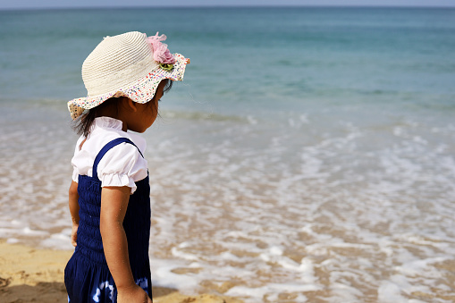 Beautiful Asia girl kid smile portrait on the beach in summer.