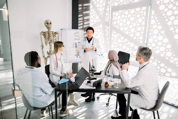 istock Chemical lab workers, doctors, scientists having a meeting. Asian man explaining a new project concept for his colleagues. Scientific discovery, medical research, scientists teamwork 1209871813