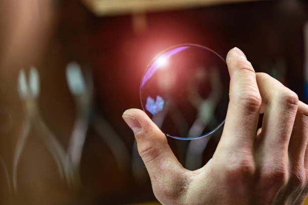 istock ophthalmologist hands showing a glass lens for spectacles. 1209872323
