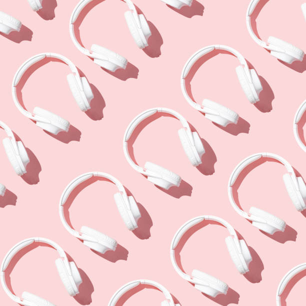 istock Pattern white headphones on modern pale pink table top view flat lay. Free space for creative design text and content 1209874271