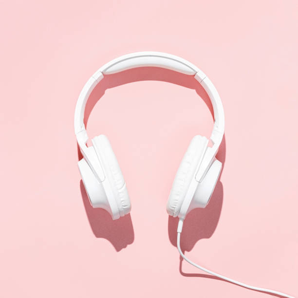istock Flat lay white headphones on modern pale pink table wallpaper. Free space for creative design text and content 1209874292