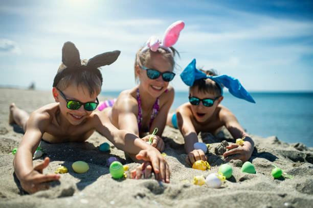 bambini che giocano in spiaggia con uova di pasqua - china sea foto e immagini stock