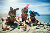 Kids playing on the beach with Easter eggs
