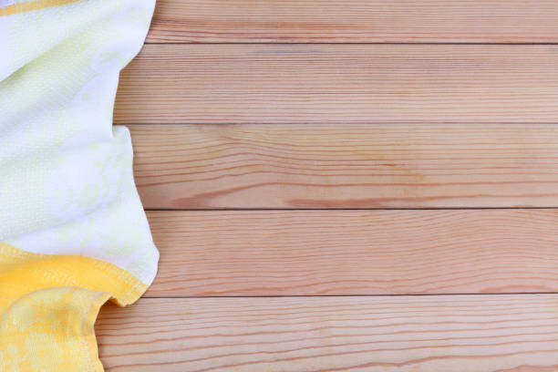 istock White, yellow towel on wooden kitchen table. View from above with copy space for text. 1209876429