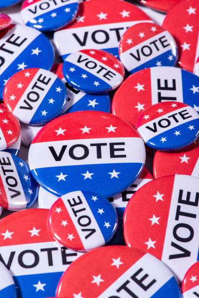 istock A bunch of various size red, white and blue VOTE buttons on a table 1209876931