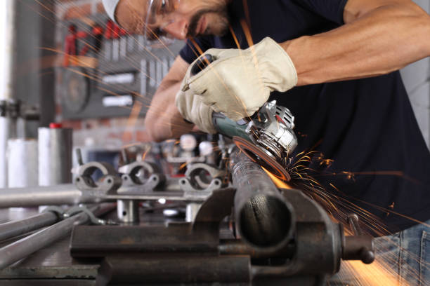 istock man work in home workshop garage with angle grinder, goggles and construction gloves, sanding metal makes sparks closeup, diy and craft concept 1209877091
