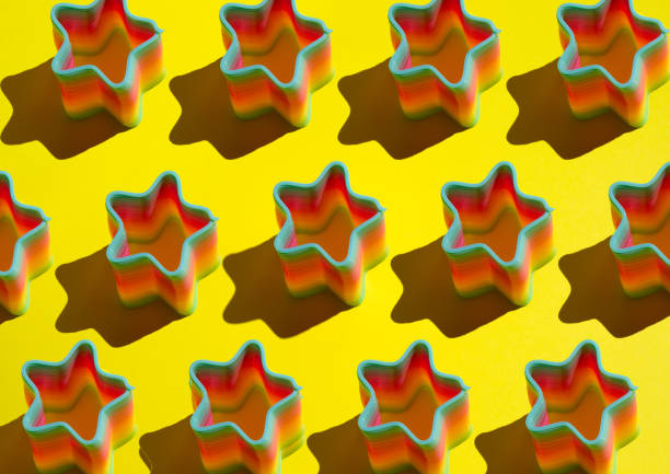 istock pattern of ranbow slinky toy on bright yellow background 1209877172