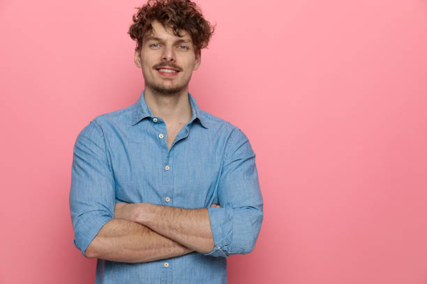 istock happy young guy smiling and crossing arms 1209878013