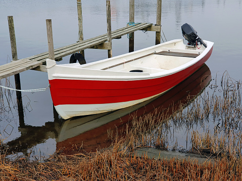 Photography of a small fishing boat at s pier in a small harbor