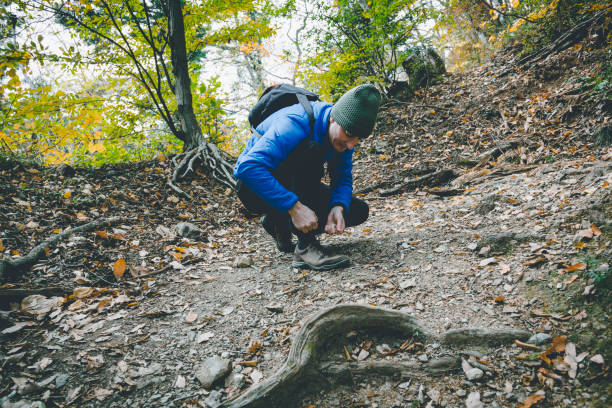 istock Man tying shoelace while hiking in the mountain 1209884418