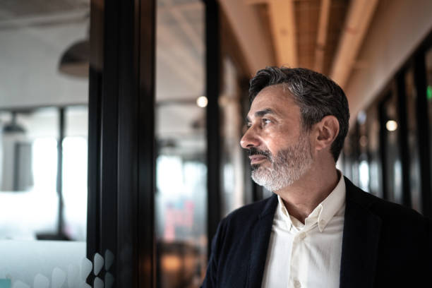 Mature businessman looking out of window