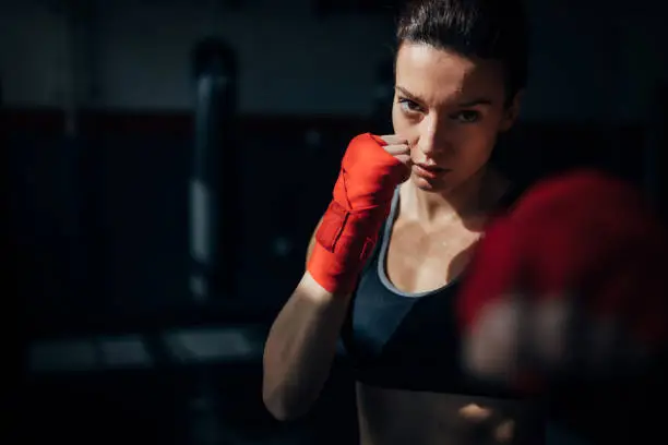 Portrait of beautiful kick boxer exercising in the gym