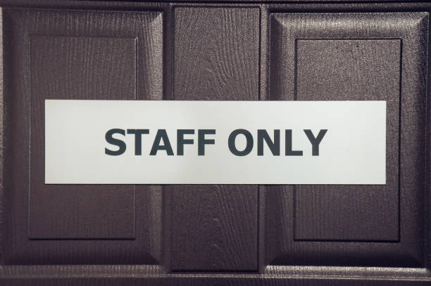 Sign or board with inscription staff only hanging on brown wooden door