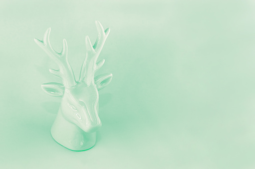 View of the sculpture of a Christmas deer in neo mint color. Winter vacation concept, minimalism, abstraction, color of the year