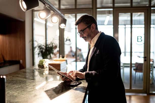 istock Mature businessman using digital tablet at modern office 1209888283
