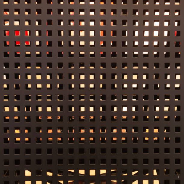istock Wall, perforated metal construction with square holes, covered with gray paint. 1209889509