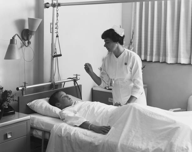 медсестра проверяет boy's температуре - image created 1960s фотографии стоковые фото и изображения