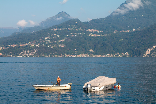 Lake Como in Lombardy, Italy. Boats with visible people are in the background.