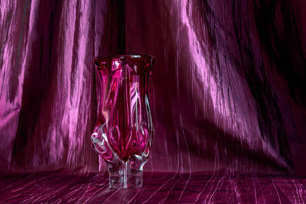 istock Purple glass vase on purple textile background 1209891914