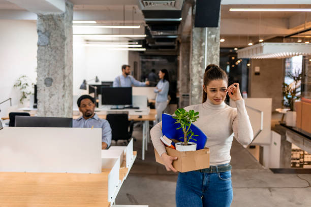 Guess it's time to say goodbye Fired businesswoman packed her bags and leaving office.She is looking sad. fired employee stock pictures, royalty-free photos & images