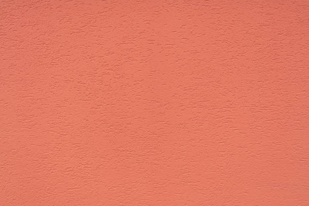istock The texture of the concrete wall is covered with decorative plaster with a rough surface and cracks in the color of coral. The concept of the structure, texture, decor. 1209893578
