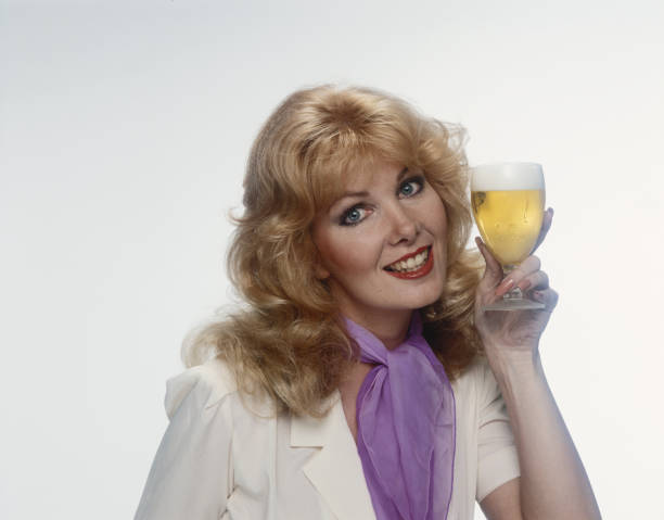 Young woman holding beer glass, smiling, portrait  1980 stock pictures, royalty-free photos & images