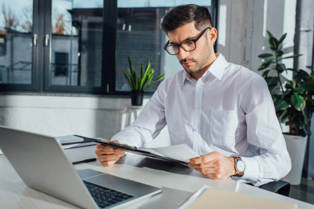istock professional male translator in eyeglasses working online with laptop 1209894285
