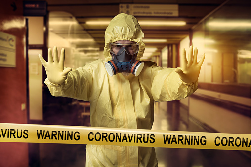 Coronavirus Warning cordon tape and men wearing protective suit