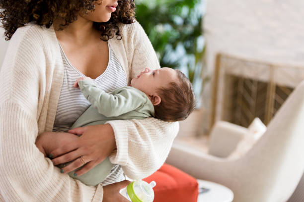 istock Mom prepares to give infant a bottle 1209896651