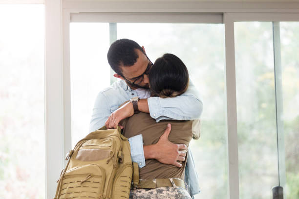 istock Husband holds wife's military backpack as he hugs her goodbye 1209896793