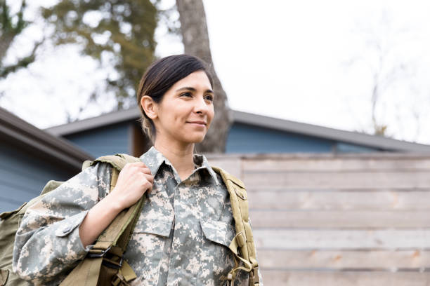 Portrait of female soldier carrying gear A portrait of a female soldier carrying her gear as she leaves her home for the deployment. camouflage clothing photos stock pictures, royalty-free photos & images