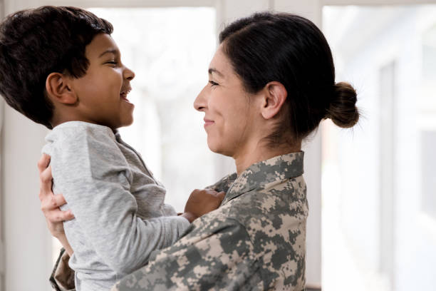 istock Mother in uniform smiles and hugs laughing son 1209896807
