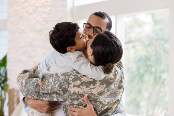 istock Small family enjoys group hug when mom arrives from deployment 1209896812
