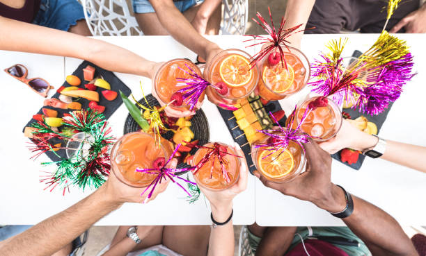 Friends hands toasting " Sex on the Beach " fancy drinks - Young people having fun together drinking cocktails at happy hour with fruit snacks buffet - Summer party time concept on bright vivid filter Friends hands toasting " Sex on the Beach " fancy drinks - Young people having fun together drinking cocktails at happy hour with fruit snacks buffet - Summer party time concept on bright vivid filter top honor stock pictures, royalty-free photos & images