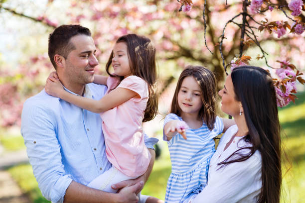 istock Young parents with small daugthers standing outside in spring nature. 1209900269