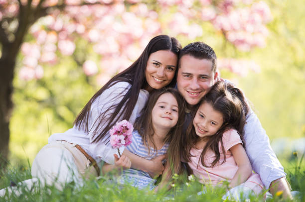 istock Young parents with small daugthers sitting outside in spring nature. 1209900286