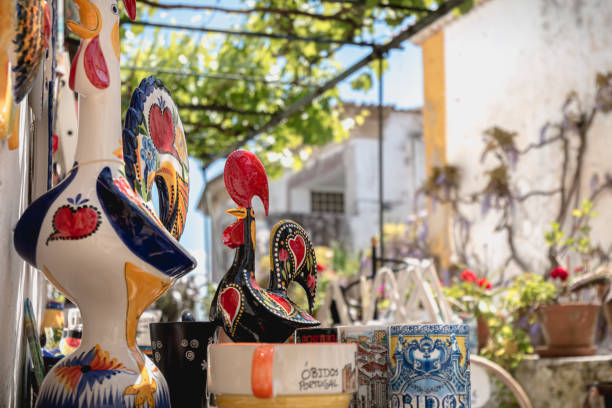 City rooster, cups, bowls and various souvenir items on Obidos, Portugal Obidos, Portugal - April 12, 2019: City rooster, cups, bowls and various souvenir items on the display of a souvenir shop in the historic city center on a spring day obidos photos stock pictures, royalty-free photos & images