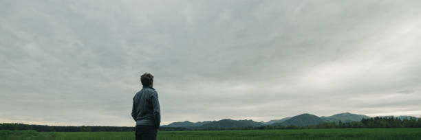 Free Stock Photo of Person Standing in Field Under Cloudy Sky ...
