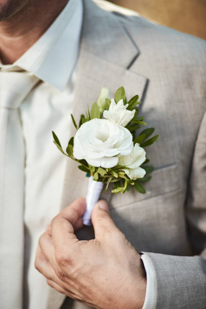 istock Groom corrects boutonniere on jacket close-up details 1209903136