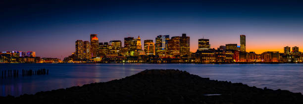 Panoramic Night Cityscape Boston Skyline and Sea Reflections from LoPresti Park in Boston, Massachusetts View of downtown Boston buildings and skyline over Mystic River in Massachusetts east boston stock pictures, royalty-free photos & images