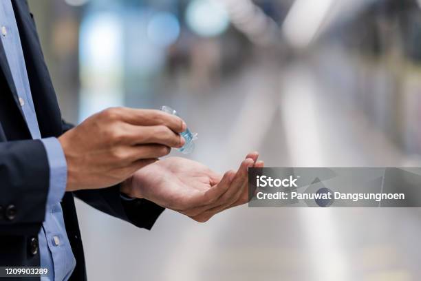 Man Hands Using Wash Hand Sanitizer Gel Dispenser Against Novel Coronavirus Or Corona Virus Disease At Public Train Station Antiseptic Hygiene And Healthcare Concept Stock Photo - Download Image Now